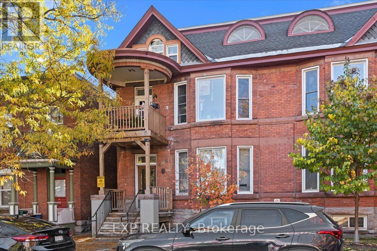 A brick house with a black car parked in front.