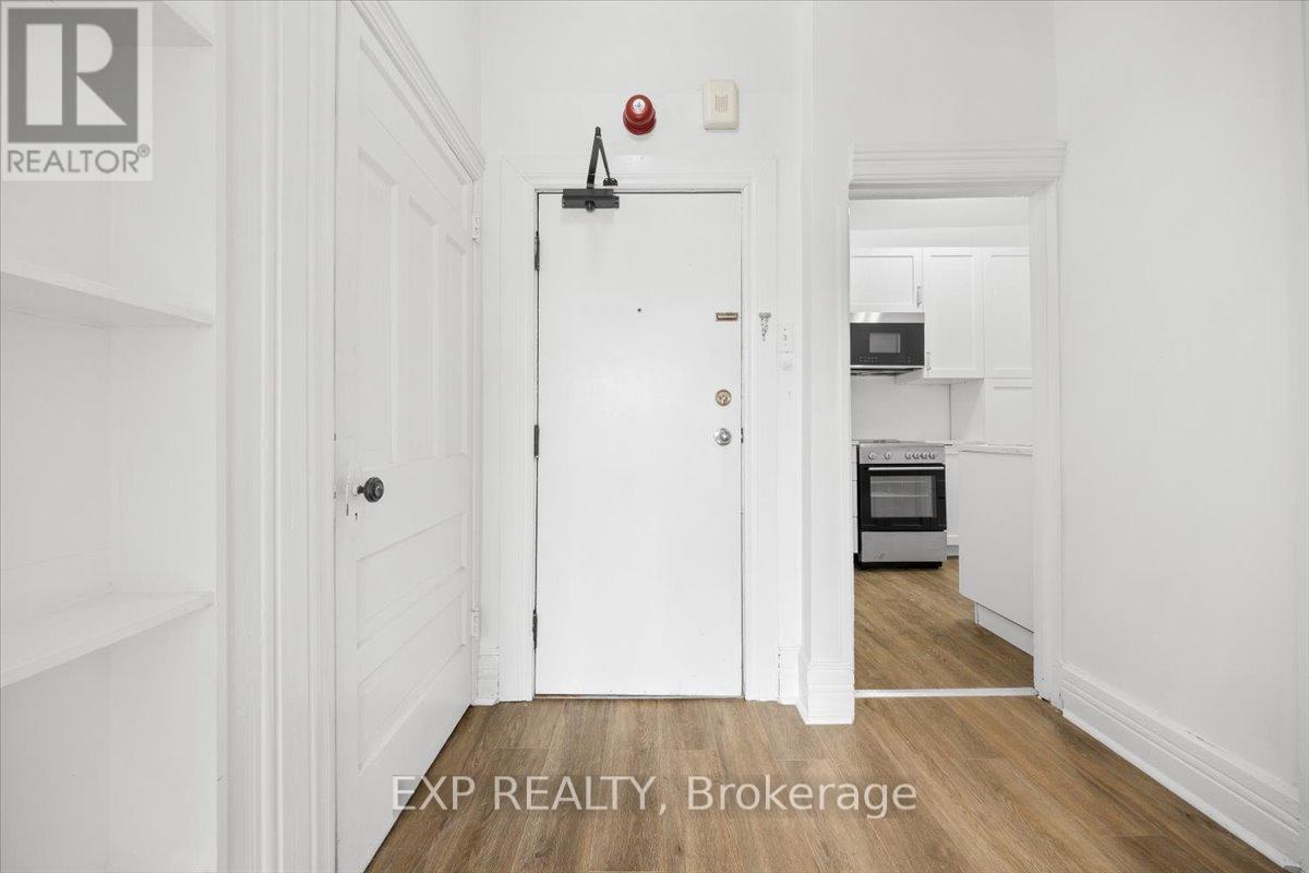 A white door with a red light above it in a hallway.