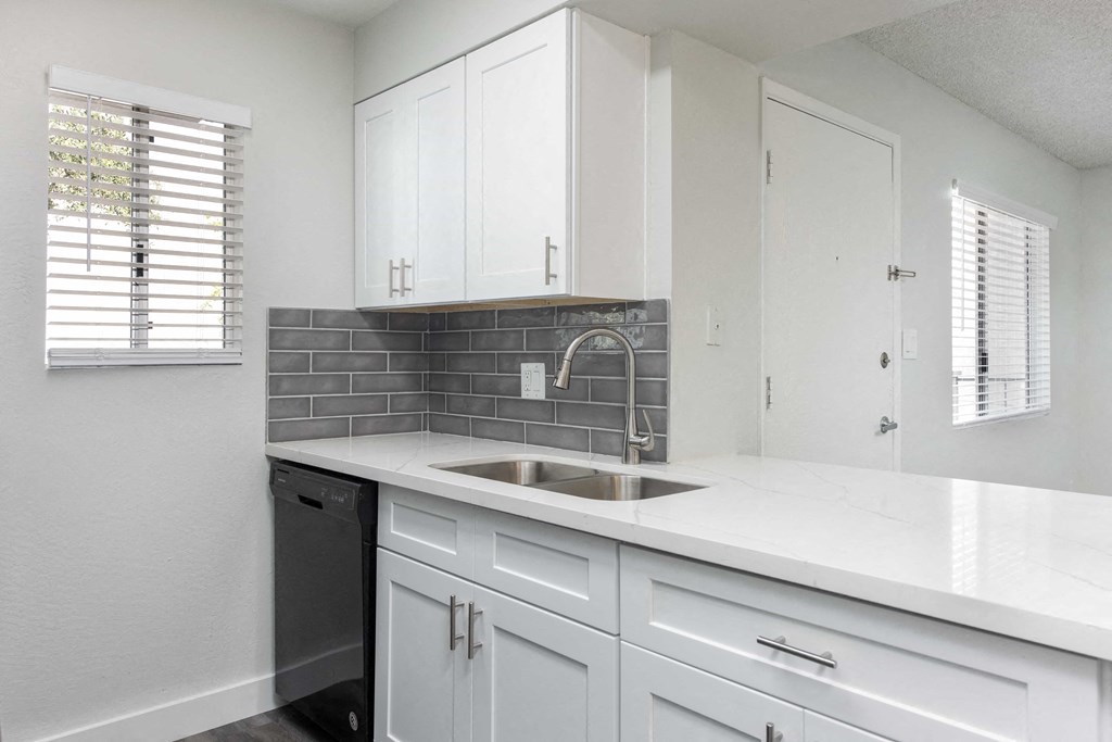 a kitchen with white cabinets and a sink