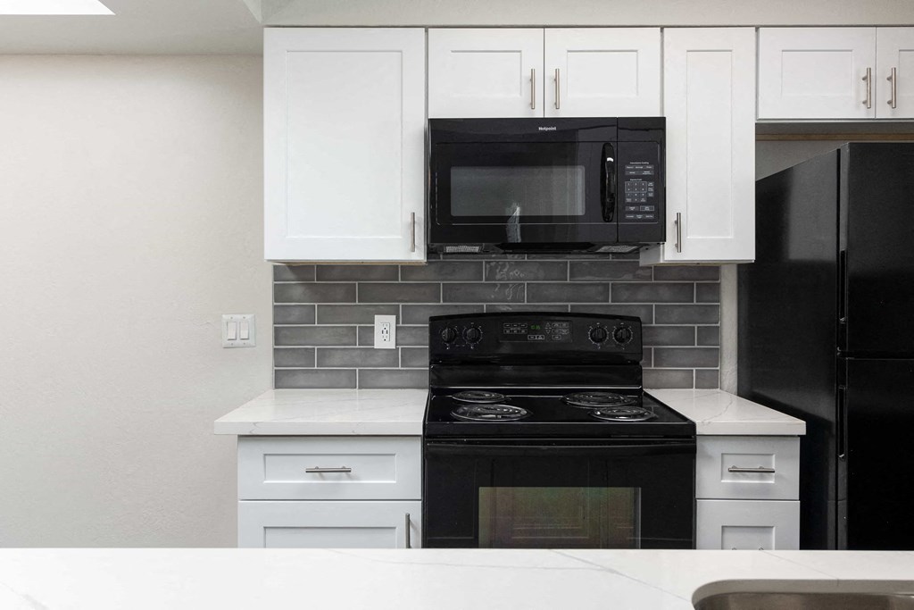 a kitchen with black appliances and white cabinets