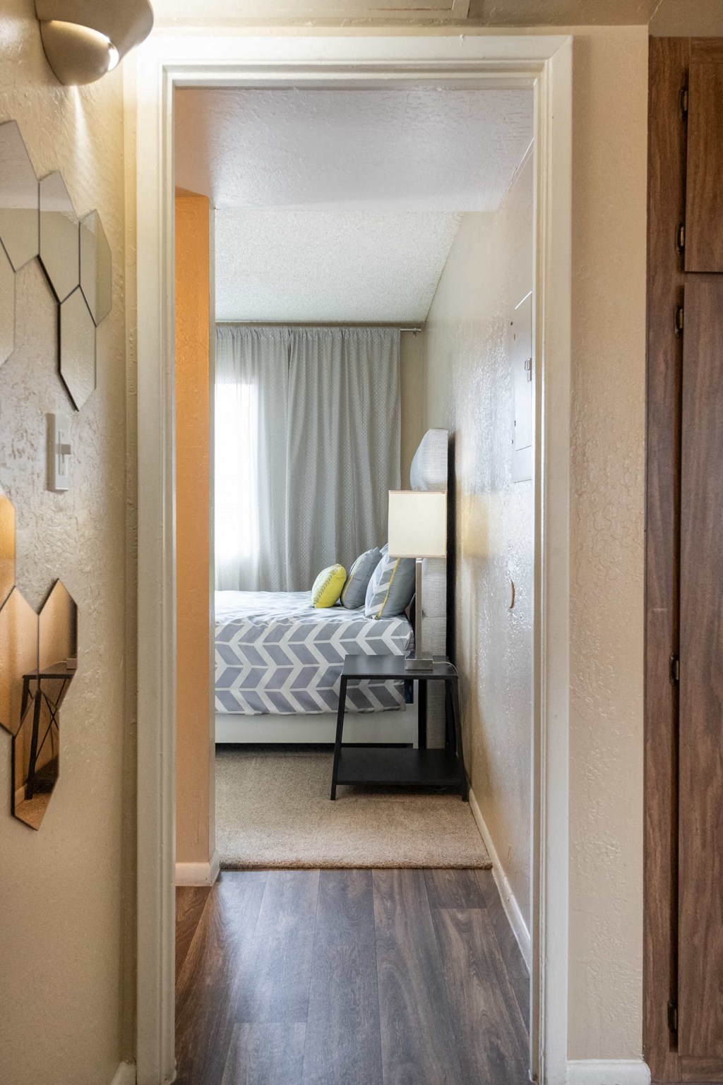 a bedroom with a bed and a lamp and a door to a room