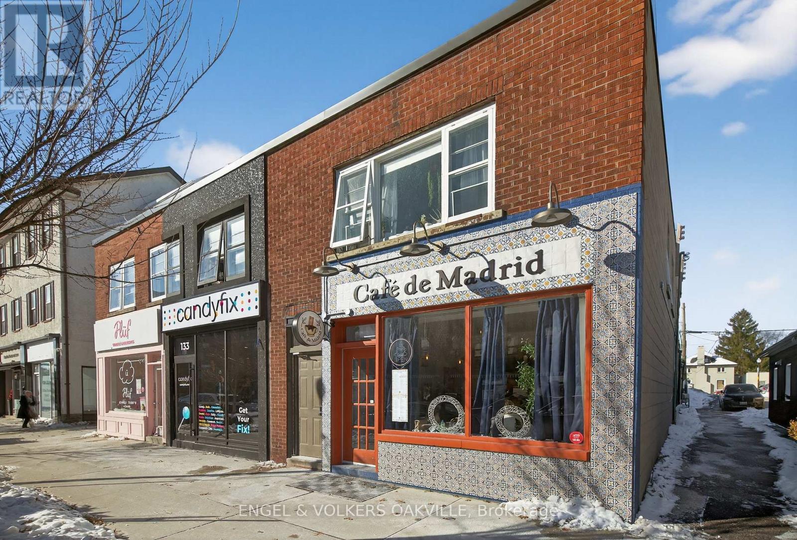 A street view of a building with a sign that reads "Calle de Madrid".