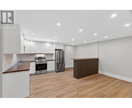 A modern kitchen with white cabinets and a wooden island.