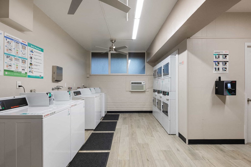 a laundry room with washing machines and sinks and a ceiling fan