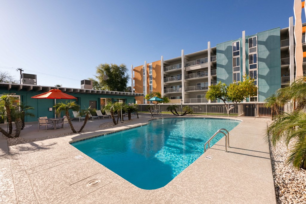 a swimming pool with an apartment building in the background