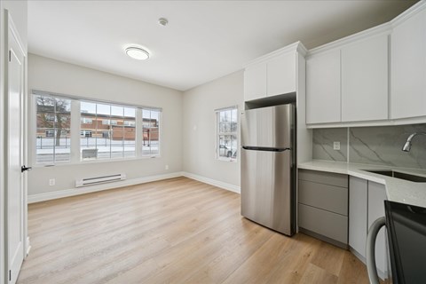 A kitchen with a refrigerator and a washing machine.