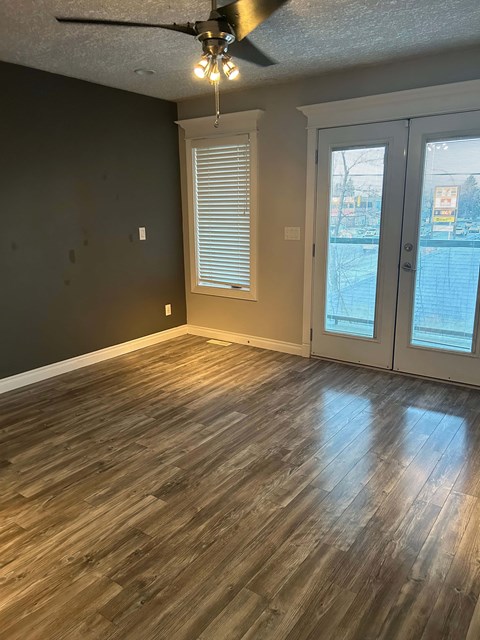 A room with wooden flooring and a ceiling fan.
