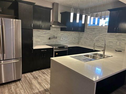 A kitchen with a stainless steel refrigerator and a white countertop.
