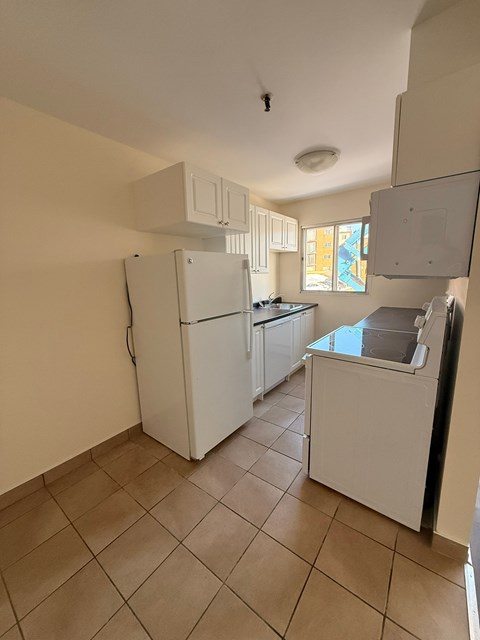 A kitchen with a white fridge and a white dishwasher.
