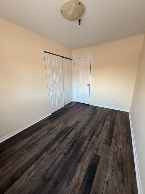 A room with a white ceiling and a wooden floor.