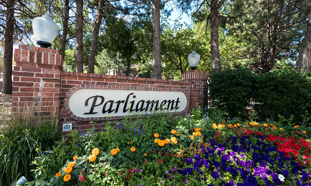 a brick wall with a sign in front of a garden