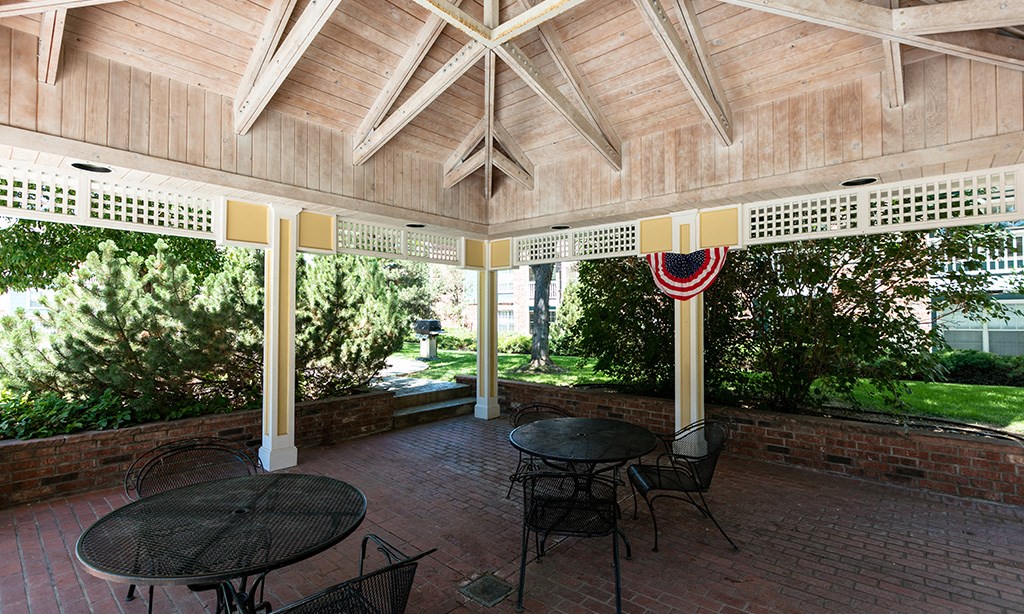a covered porch with tables and chairs and a flag
