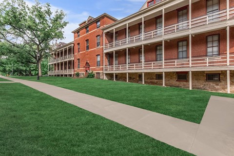 A red brick building with a long white walkway in front.