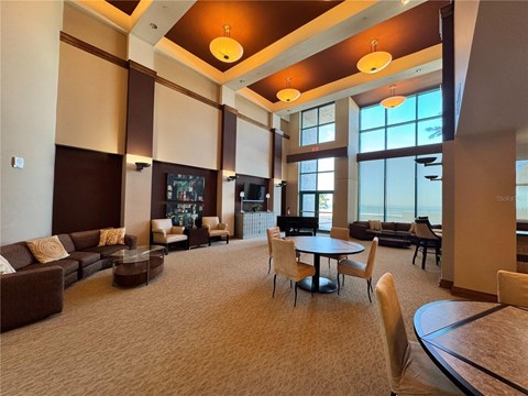 A spacious living room with brown and beige furniture and a large window.