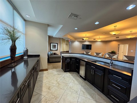 A modern kitchen with black cabinets and a large island.