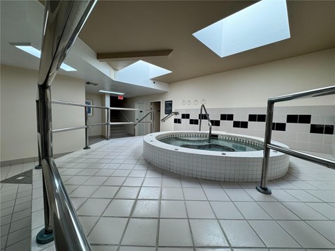 A hot tub in a room with a skylight.