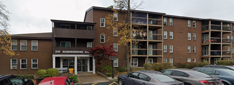 A parking lot in front of a multi-story apartment building.