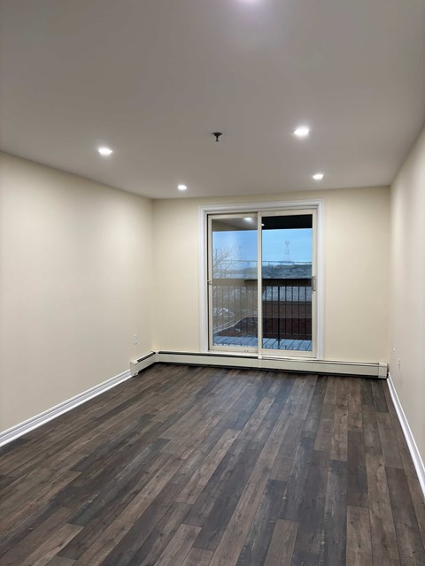 A room with a window and a view of a balcony.
