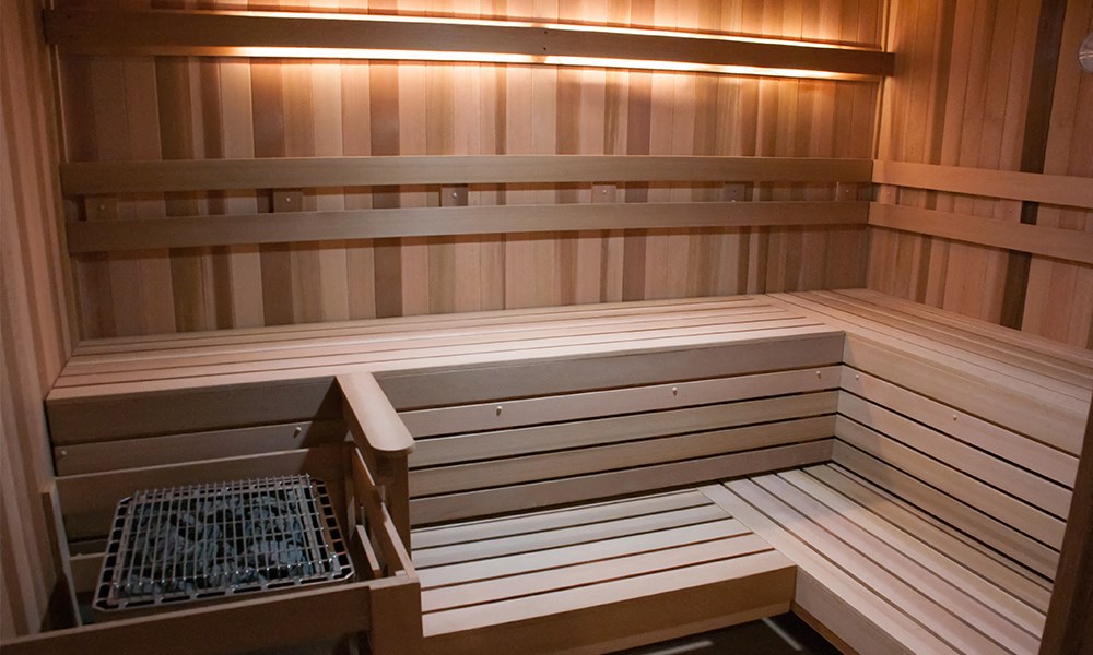 a sauna in a wood paneled room with a grate
