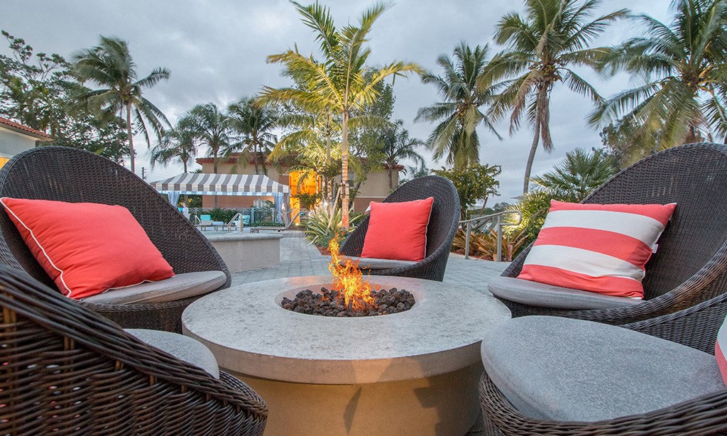 a patio with chairs and a fire pit