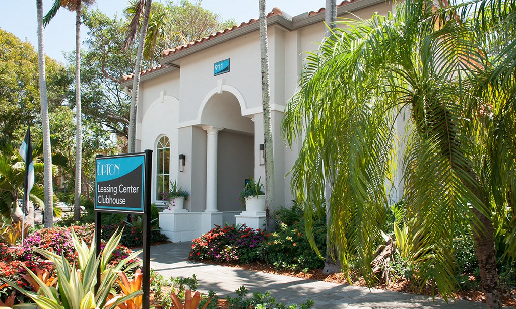 a building with a sign and palm trees in front of it