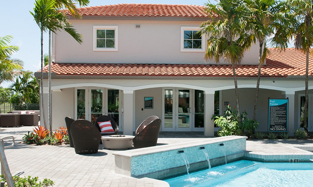 a house with a pool and chairs in front of it