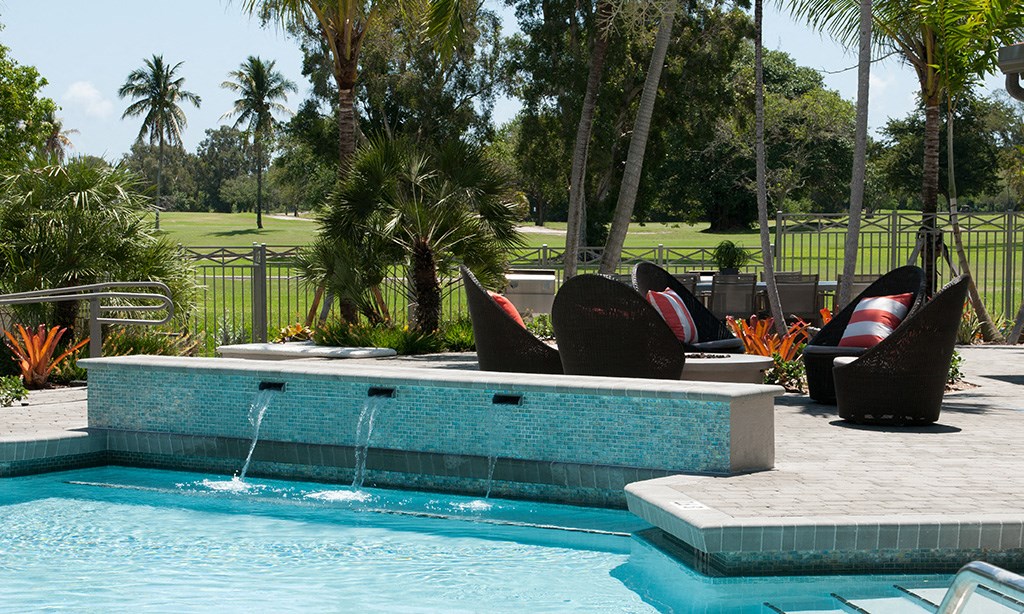 a swimming pool with a blue tiled pool     and some chairs