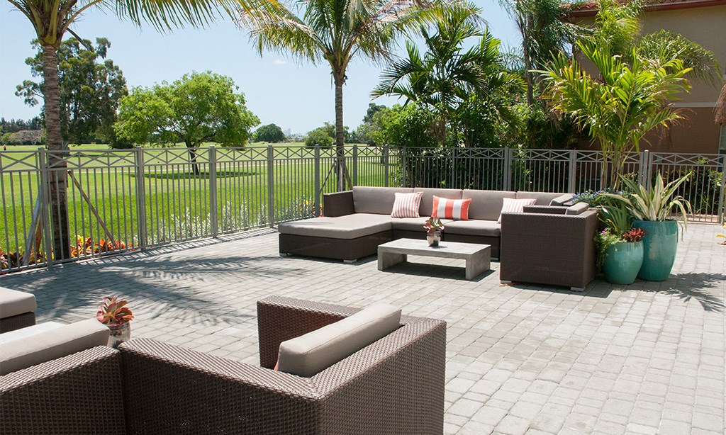 a patio with couches and a table in front of a fence