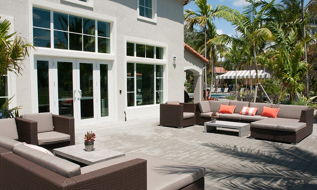 a patio with couches and tables outside of a house