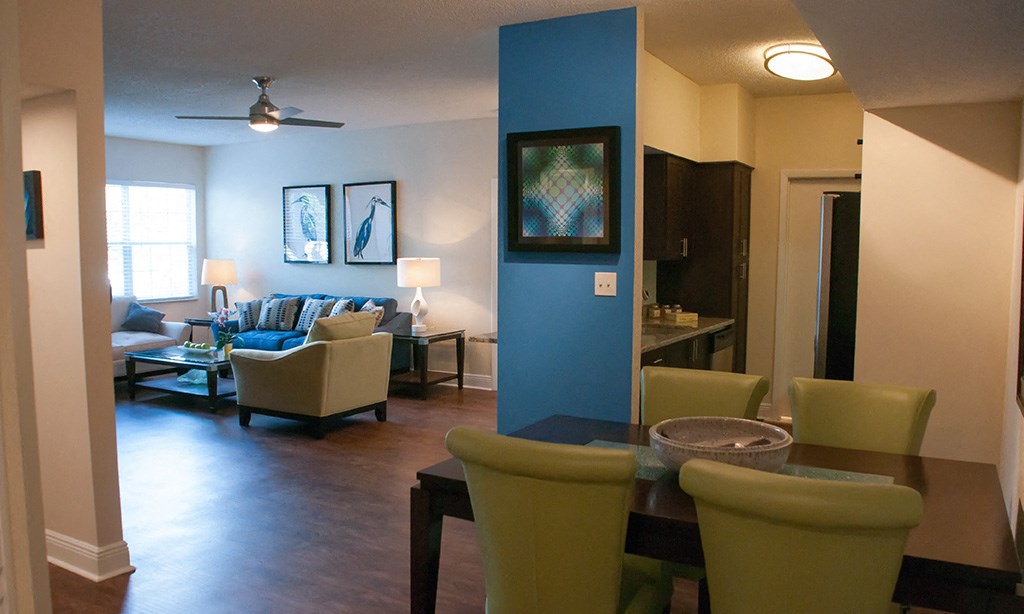 a living room and dining room with a blue accent wall