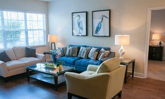 a living room with a blue couch and chairs and a table