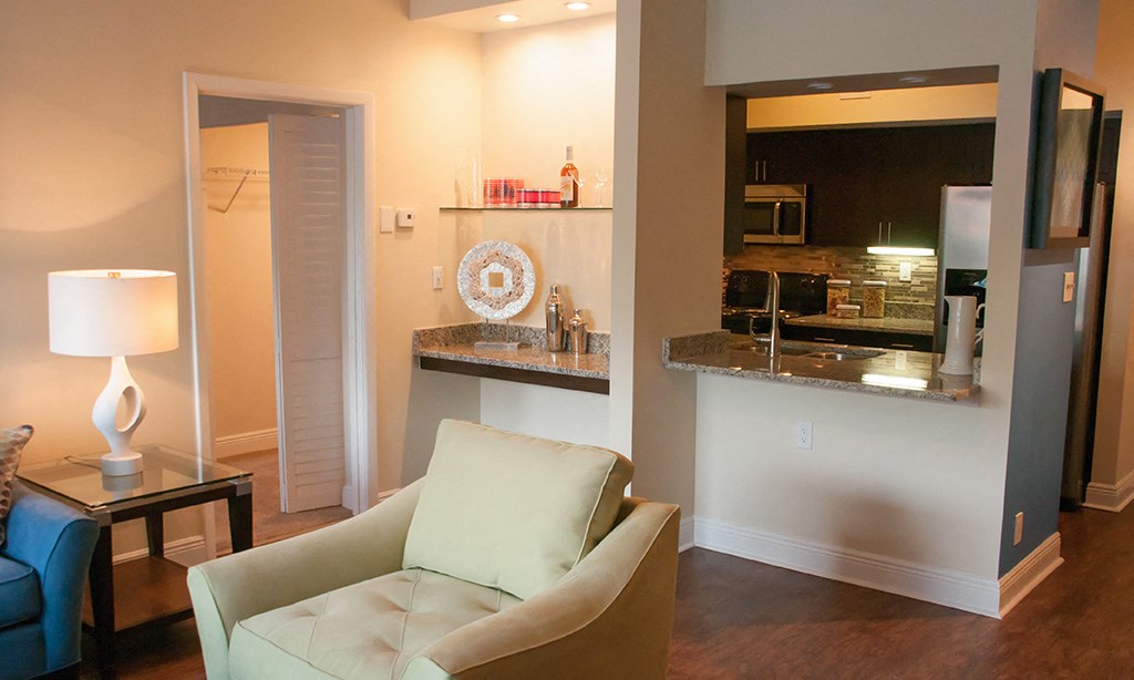 a living room and kitchen with a couch and a table