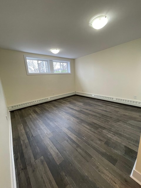 A room with a window and a radiator on the wall.