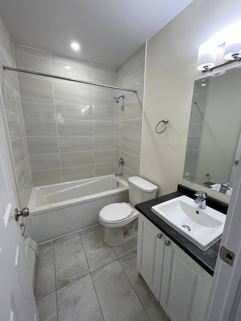 A bathroom with a white tub, toilet, and sink.