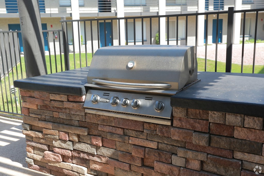 a barbecue grill on top of a brick wall