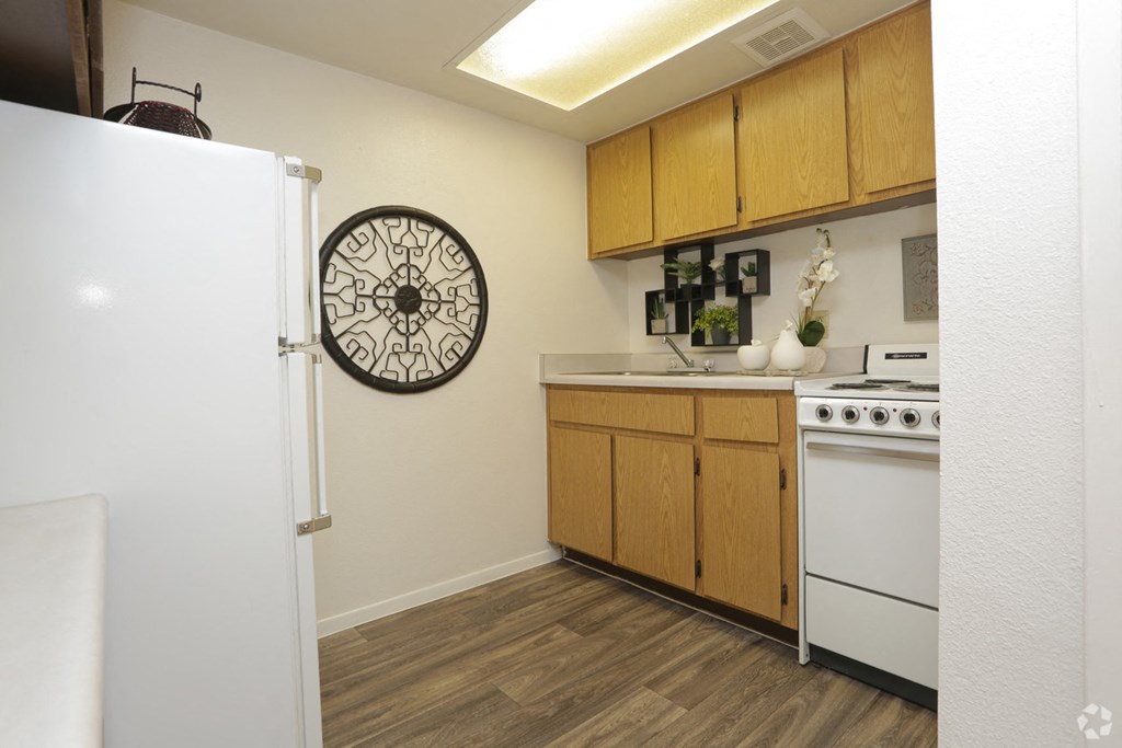 a kitchen with white appliances and a clock on the wall