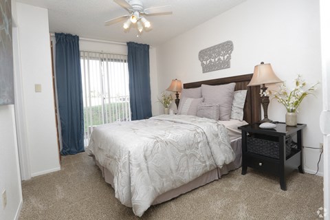 a bedroom with a large bed and a ceiling fan