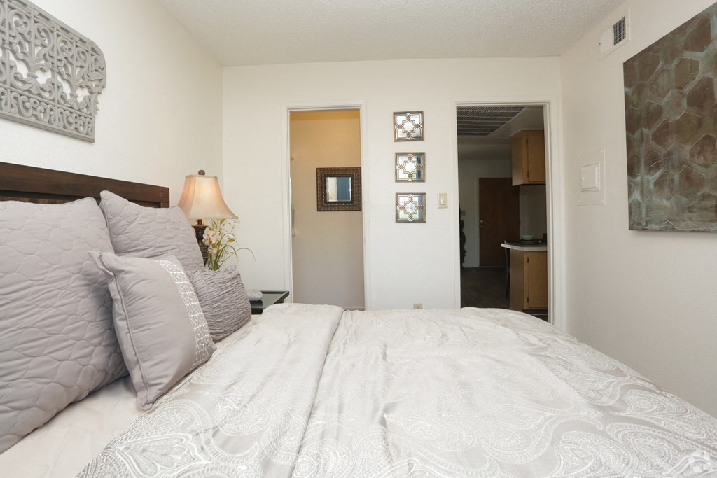 a bedroom with a large bed and a door to a bathroom