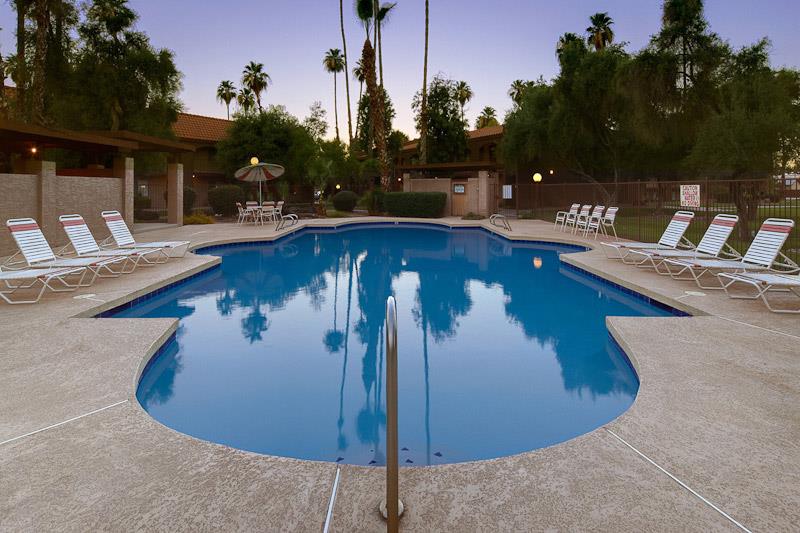 a large swimming pool with white chairs around it