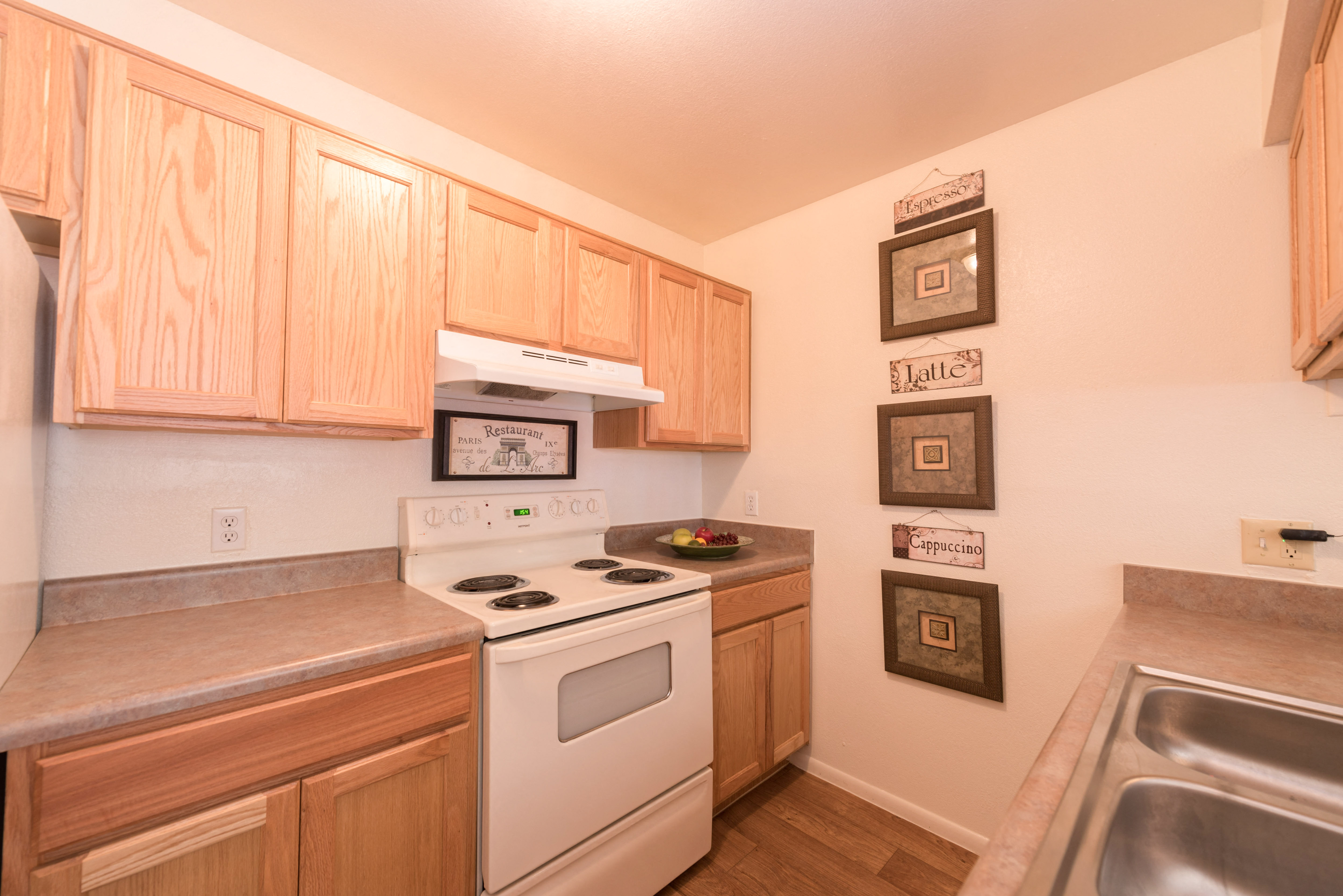a kitchen with white appliances and wooden cabinets