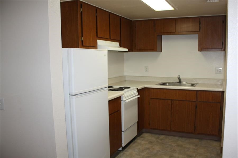 a kitchen with a white refrigerator and a sink