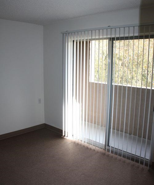 a living room with a sliding glass door and a window
