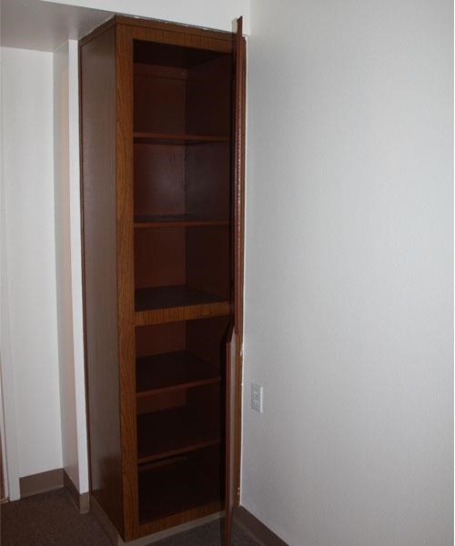 a wooden closet with shelves in a white room