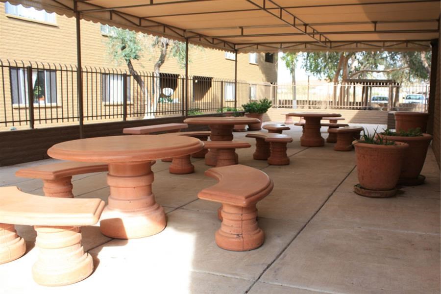 a group of benches and tables under a patio