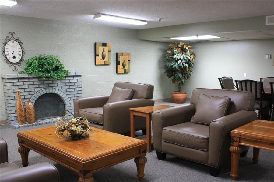 a living room with leather chairs and a fireplace