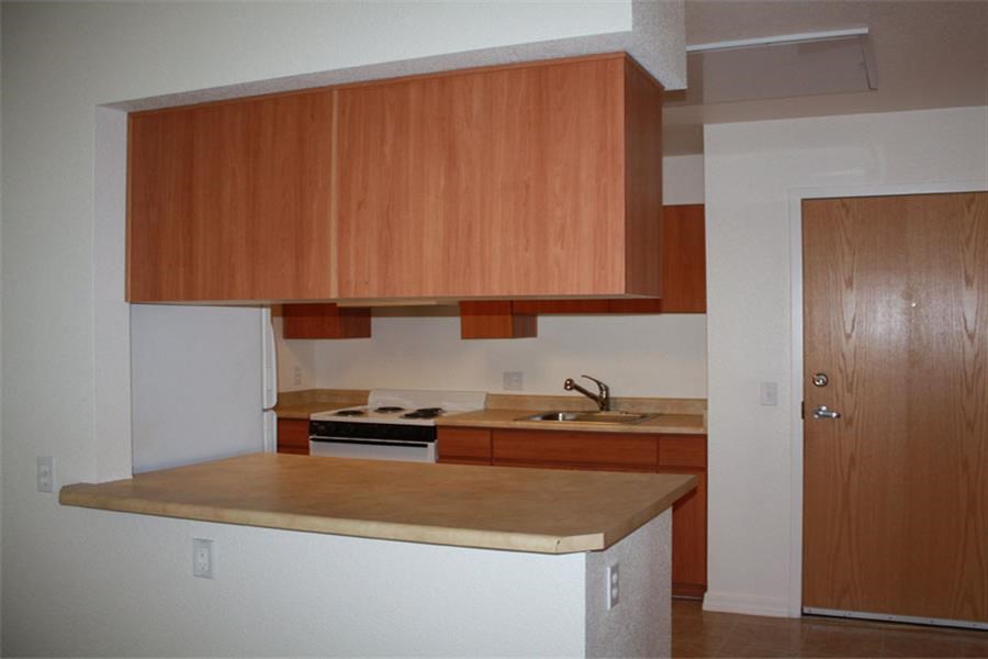 an empty kitchen with a stove and a sink