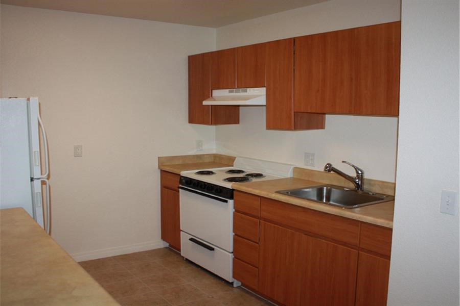 an empty kitchen with a stove and a sink