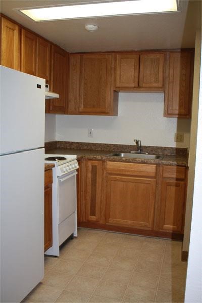 a kitchen with a stove refrigerator and sink