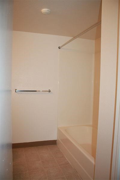 a white bathroom with a shower and a tub