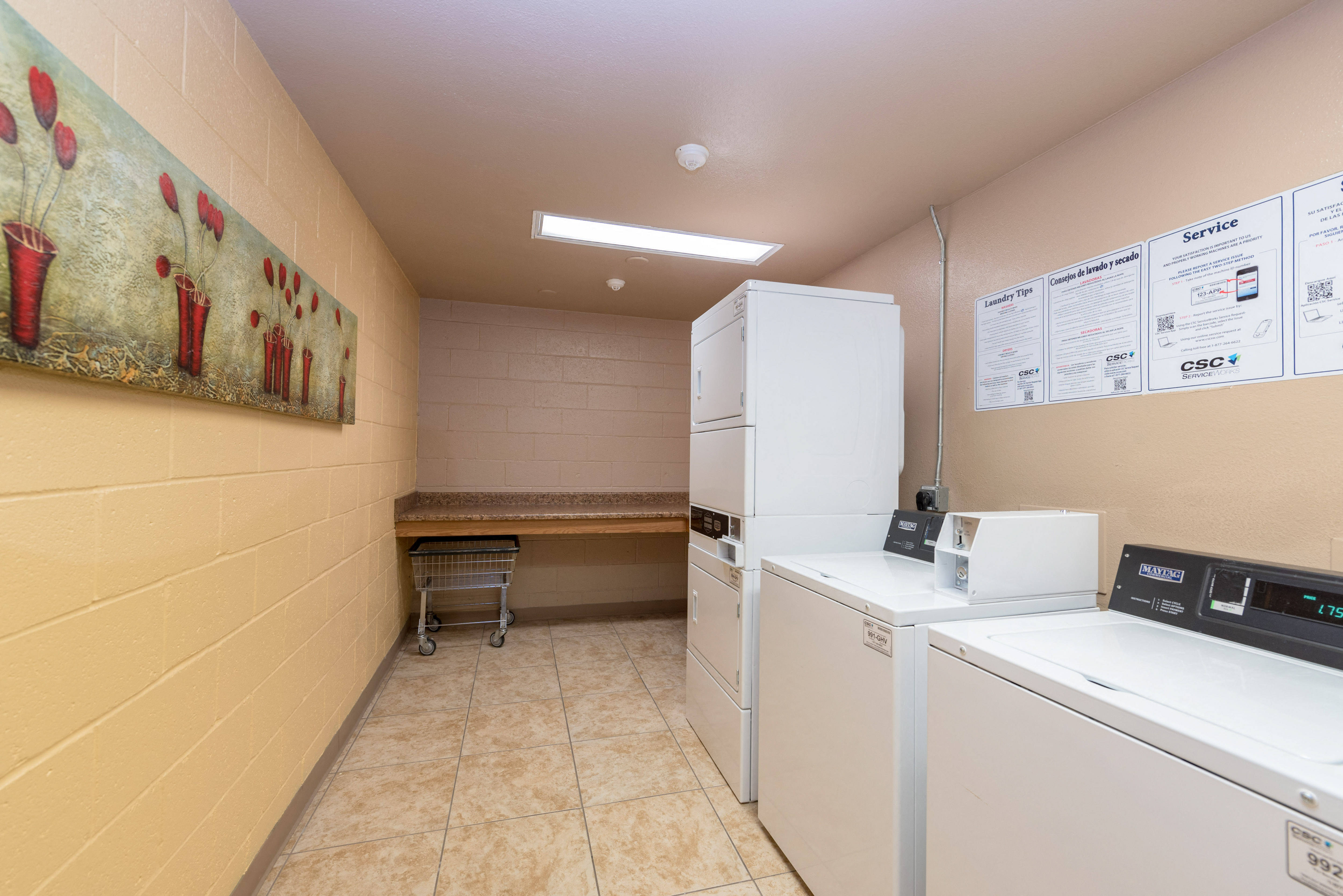 a laundry room with two washer and dryers and a sink and a refrigerator
